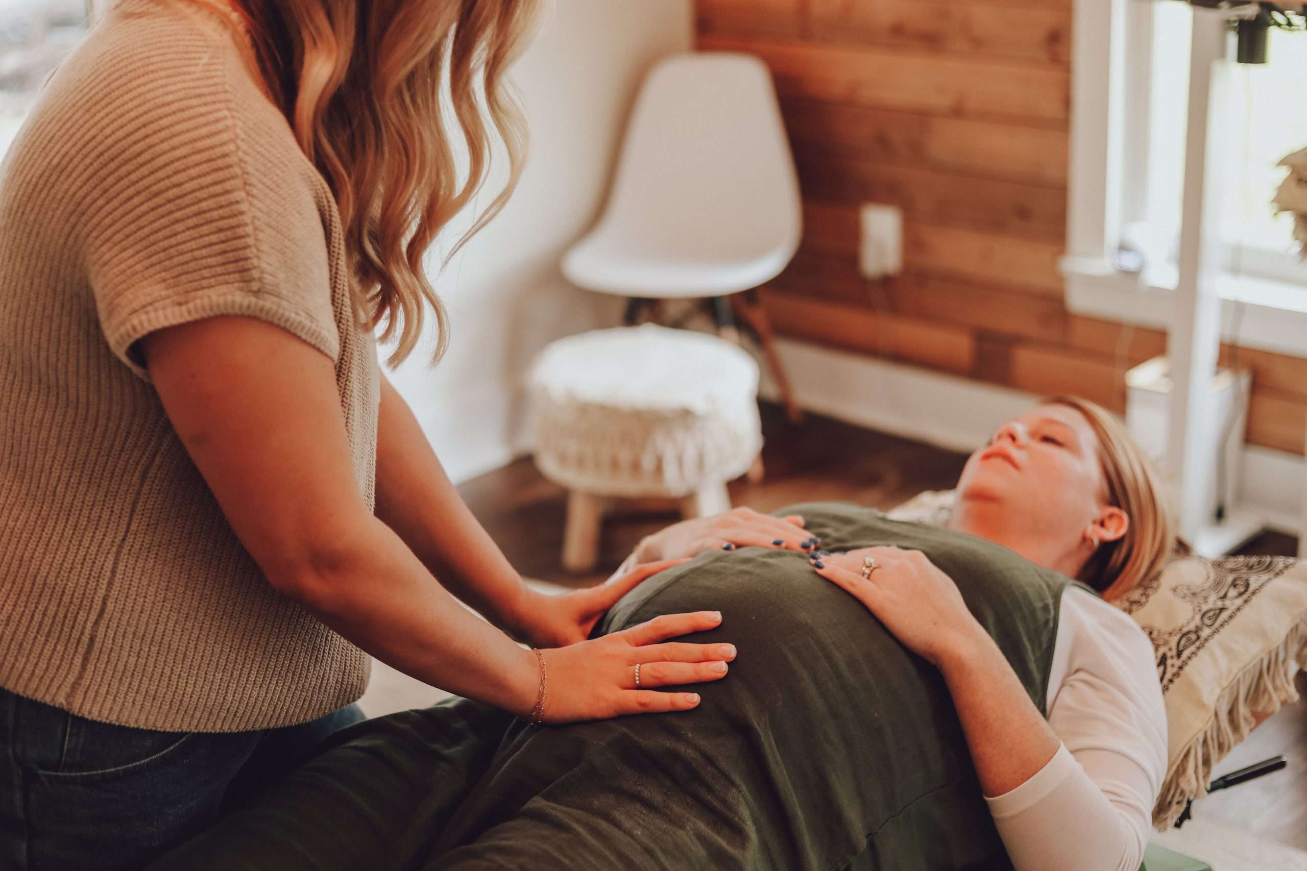 Doula warmly supporting an expecting mother during a care session